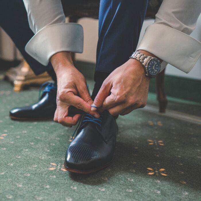 Anziehen des Bräutigams während des Getting Ready bei einer Hochzeit in Zwickau, Sachsen