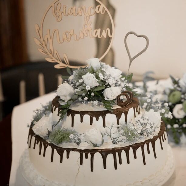 weiße Hochzeitstorte mit Schokoladenrand und weißen Rosen verziert