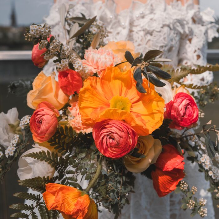 schöner Brautstrauß aus orangnen, Roten und weißen Blüten sowie Farnen für eine Hochzeit in der Elblounge in Dresden