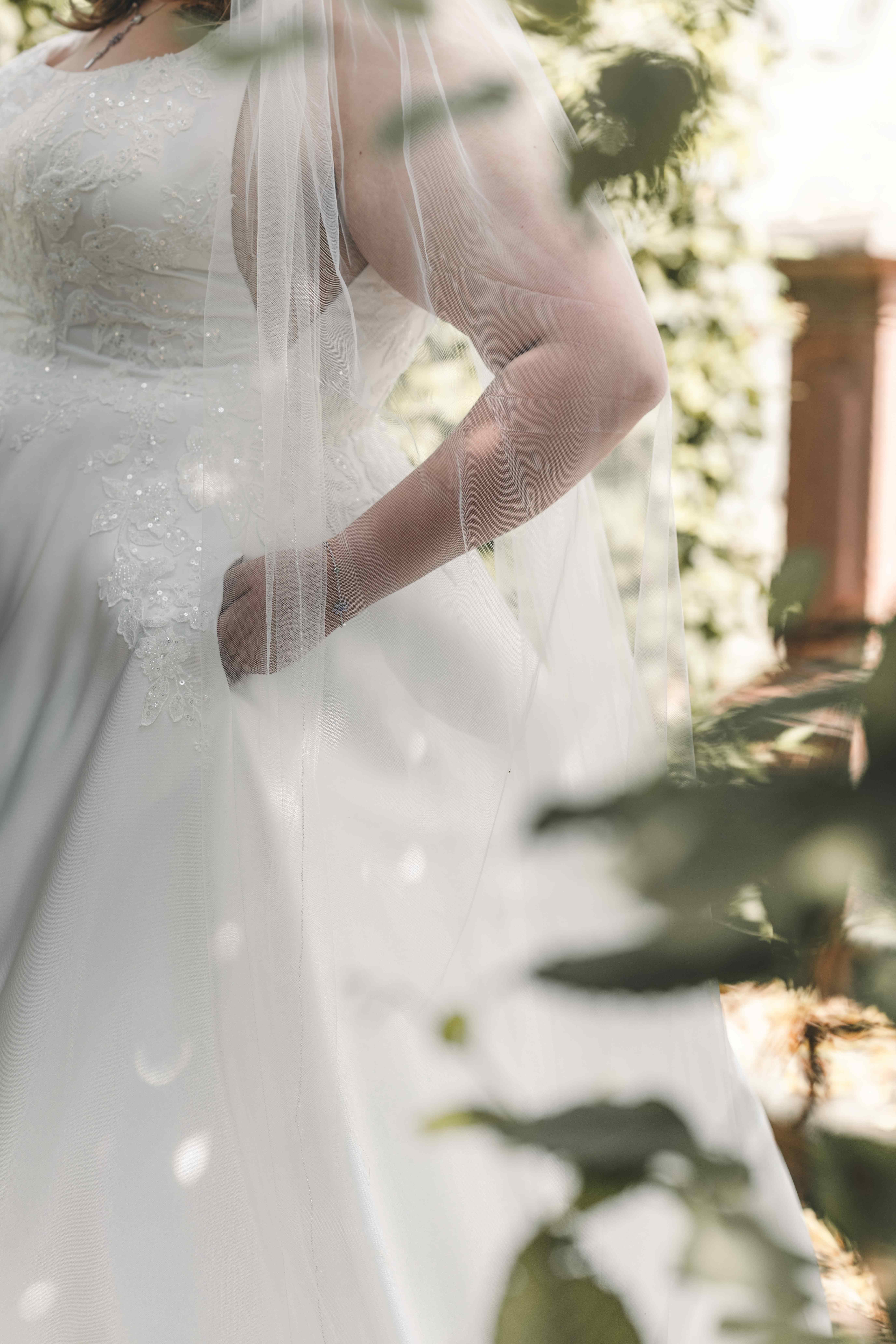 Hochzeitsreportage im Schlosspark Lichtenwalde, Nahaufnahme von Brautdetails, Brautkleid mit Taschen, Glitzer und einem Schleier, Hochzeitsfotografin Sachsen