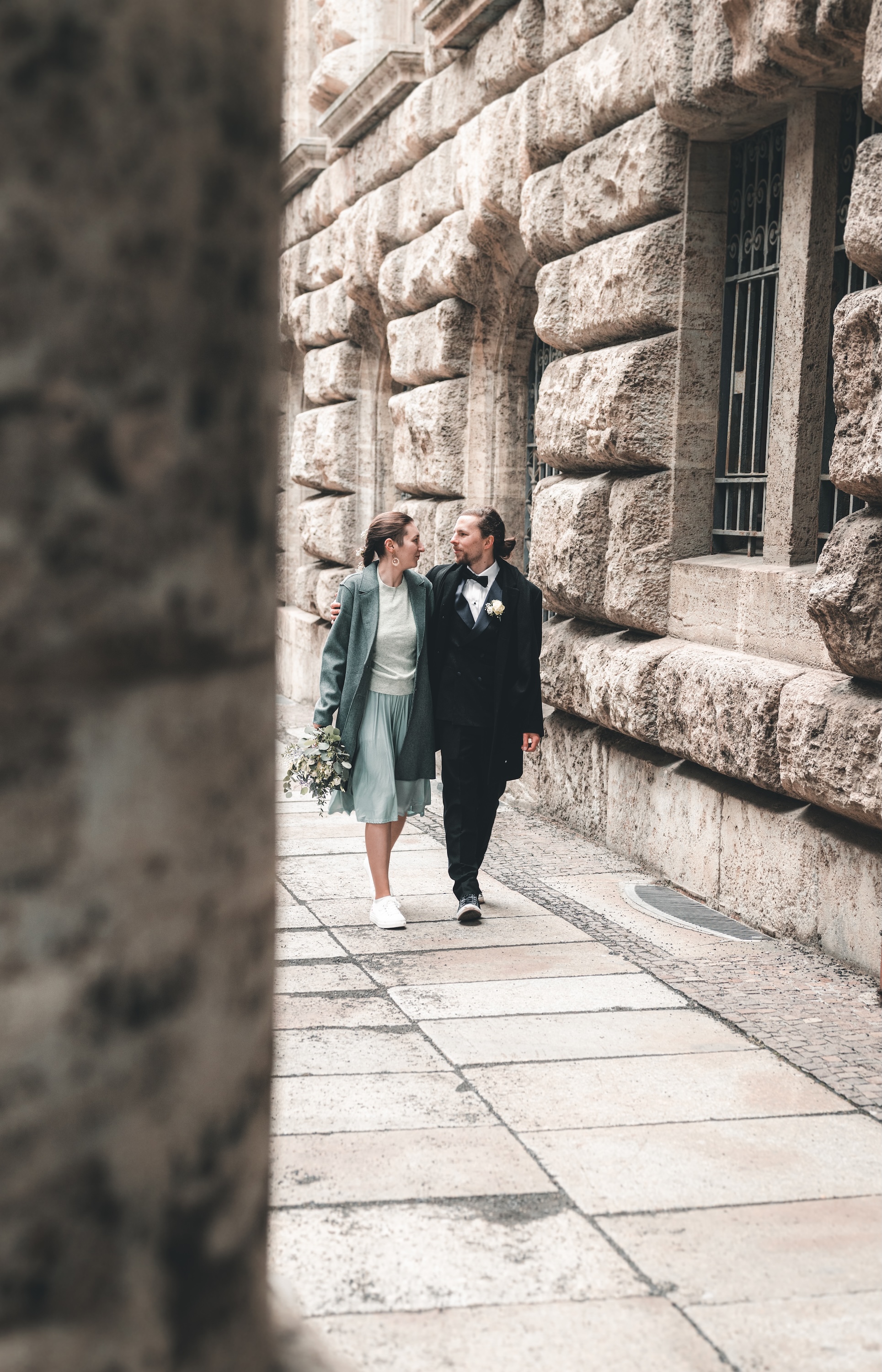 Brautpaar läuft Hand in Hand durch Leipzig vor historischer Architektur – modernes Hochzeitsfoto