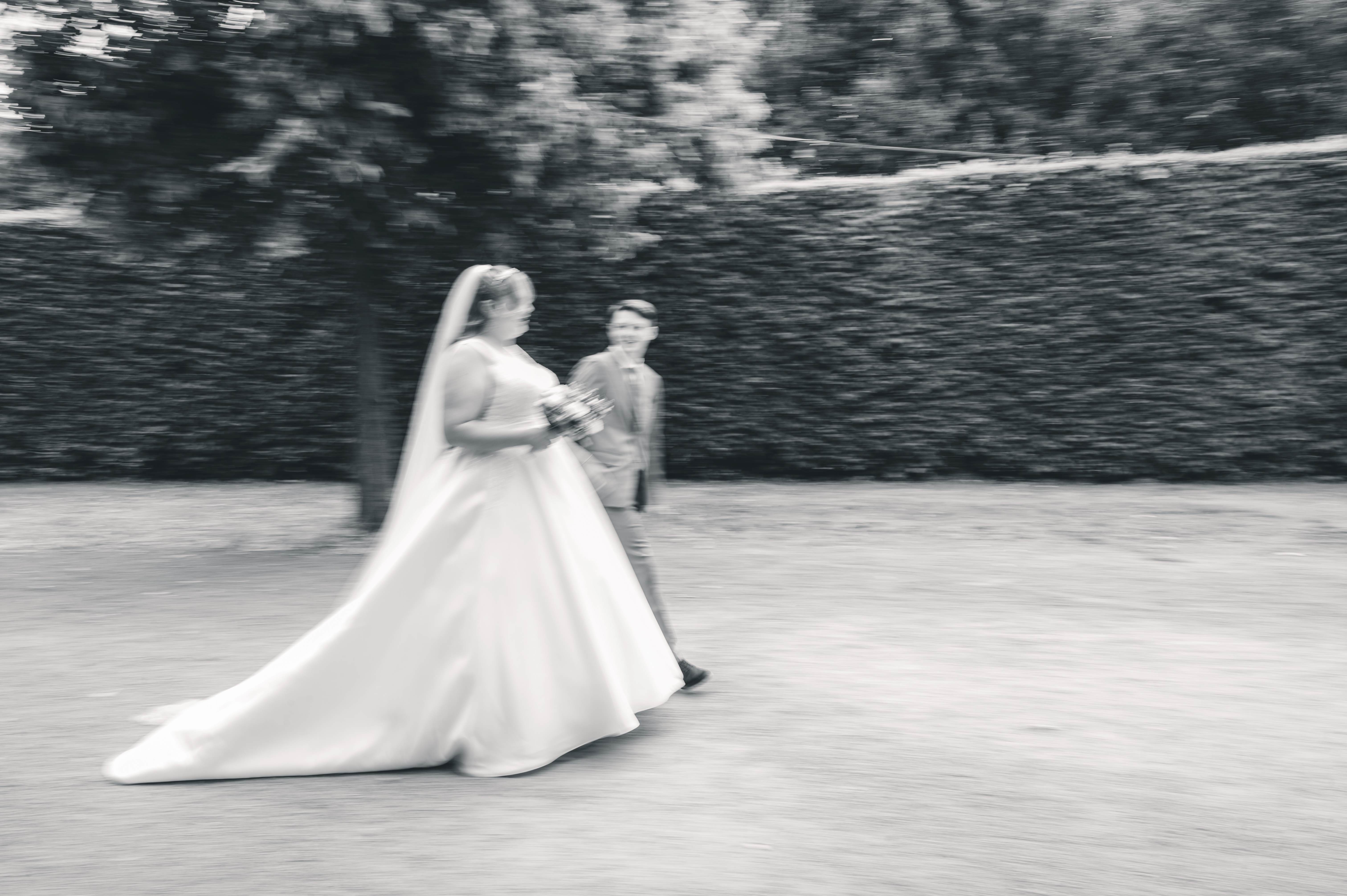 Brautpaar läuft gemeinsam durch den Park von Schloss Lichtenwalde während eines natürlichen Brautpaarshootings einer Ganztagesreportage