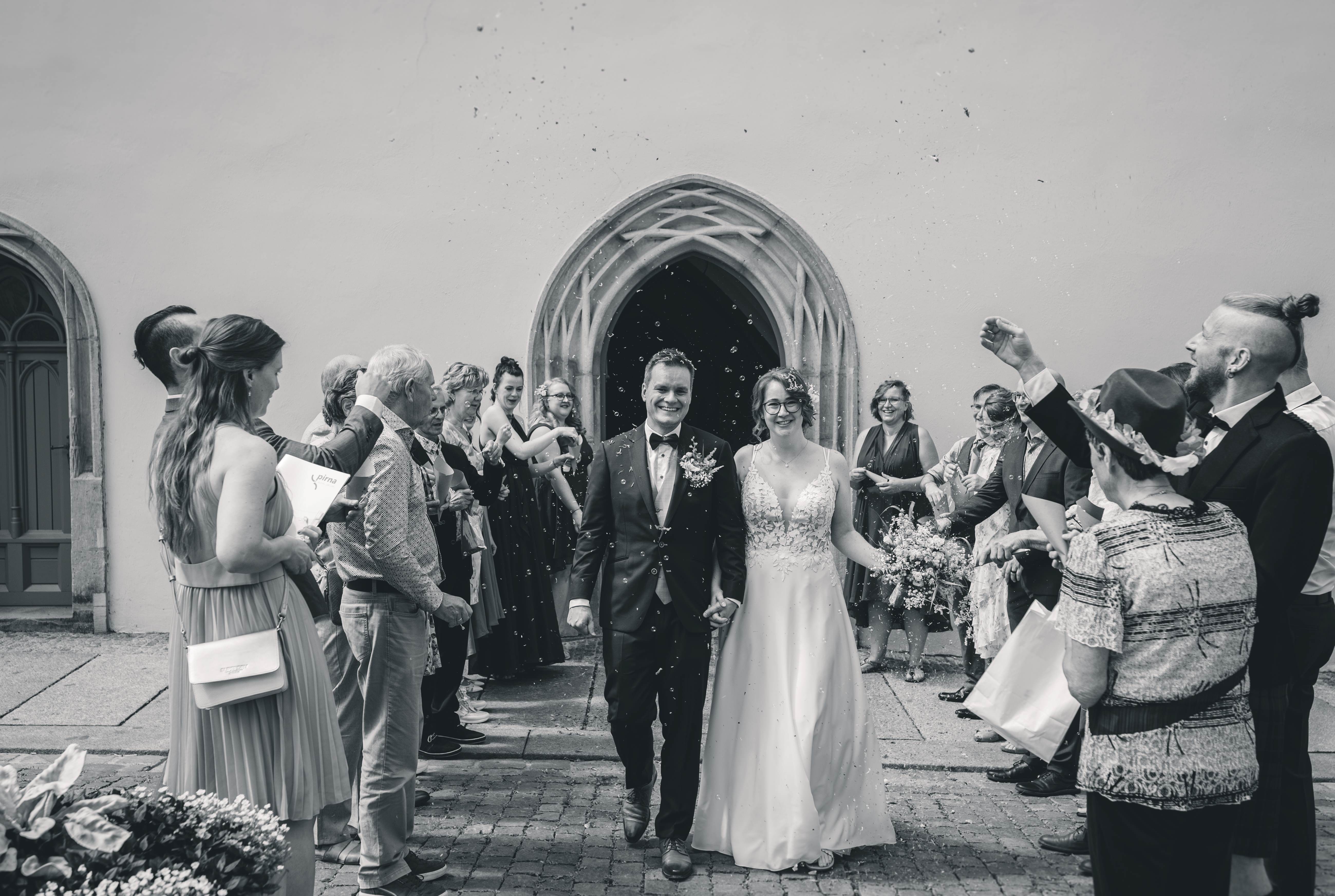 Brautpaar beim Auszug aus dem Standesamt Pirna nach der Trauung mit jubelnden Hochzeitsgästen – emotionale Hochzeitsreportage in Sachsen