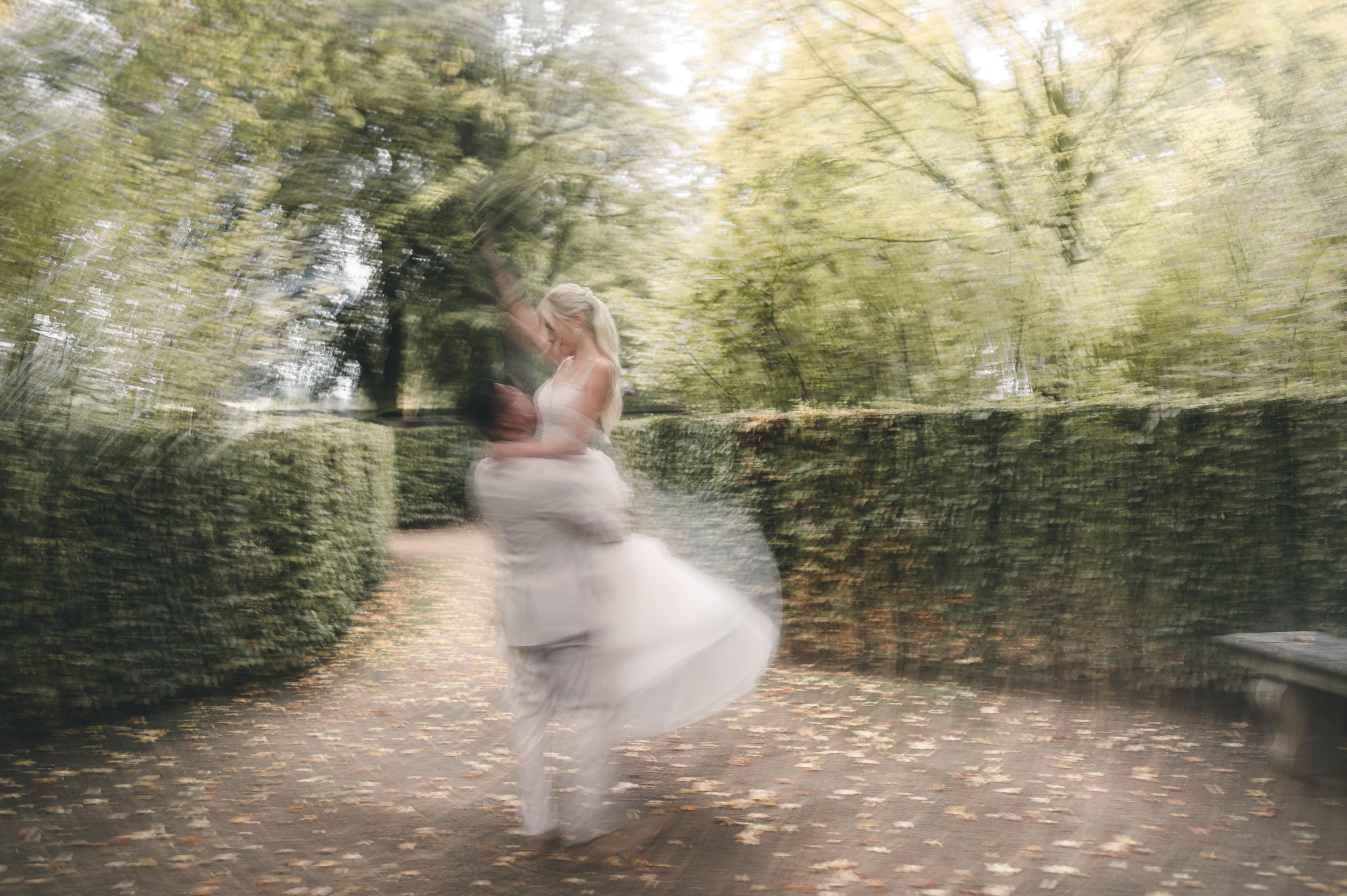 Brautpaar dreht sich im Park von Schloss Wackerbarth in Radebeul während einer Ganztages-Hochzeitsreportage – elegantes Brautpaarshooting