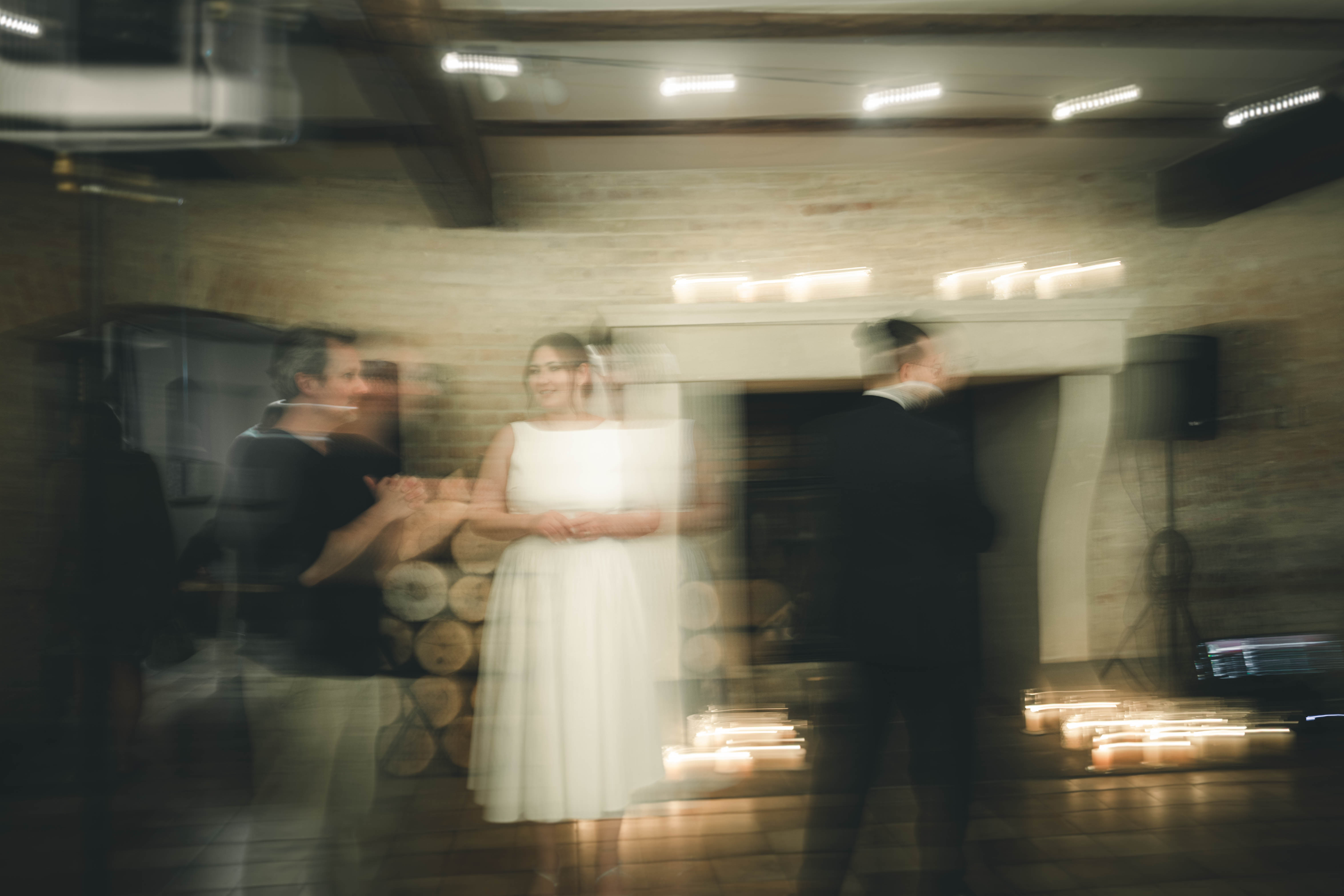 Stimmungsvolles Foto mit Bewegungsunschärfe von Braut und Bräutigam vor dem beleuchteten Kamin während der Eröffnung der Tanzfläche im Magdalenengut Erfurt.