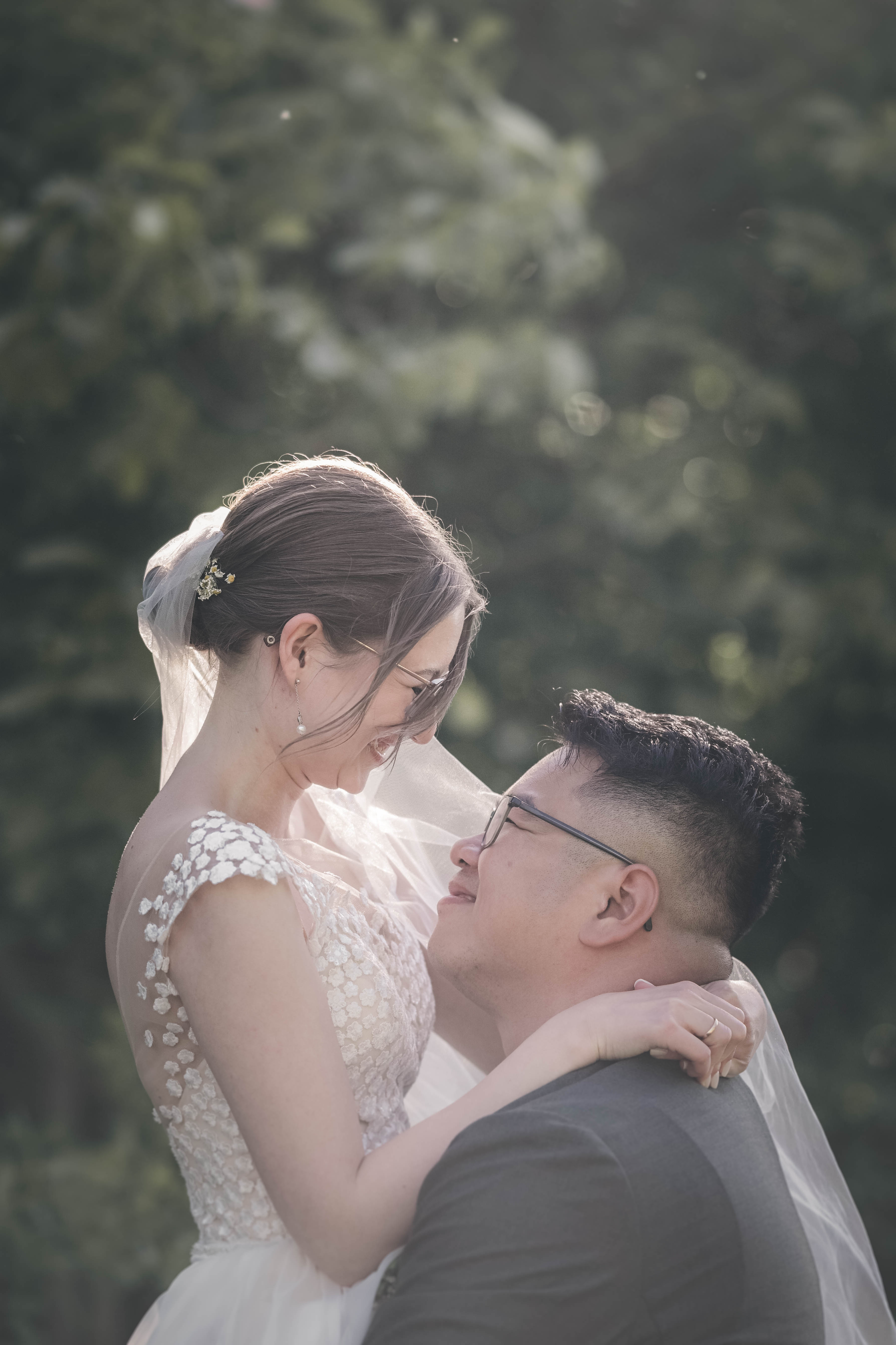 Viet Anh hält seine Braut Maja auf den Armen, während beide sich tief in die Augen blicken und sich zärtlich anlächeln.