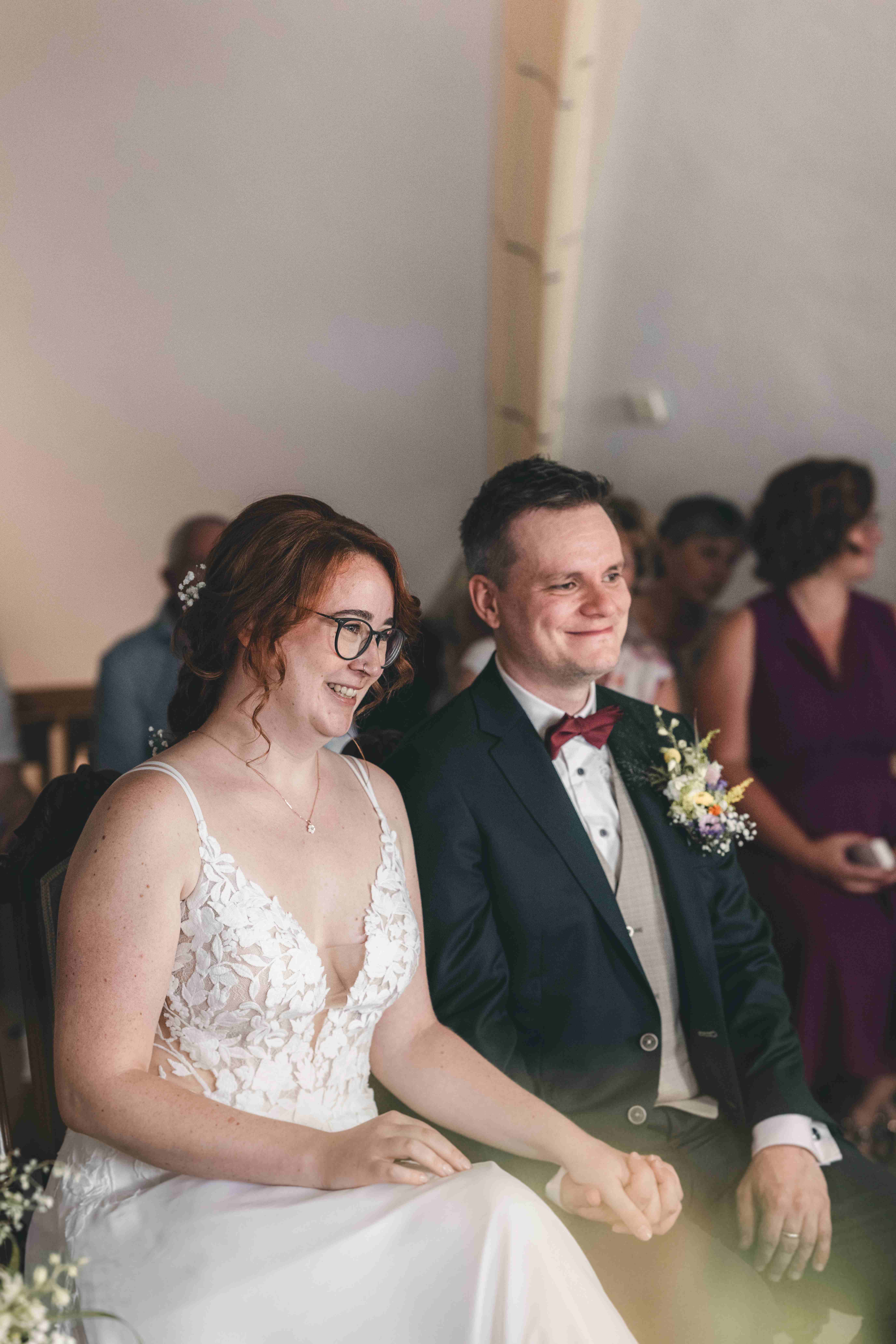 Rebecca und Dennis halten sich während der emotionalen Rede im Standesamt Pirna an den Händen und blicken glücklich nach vorn.